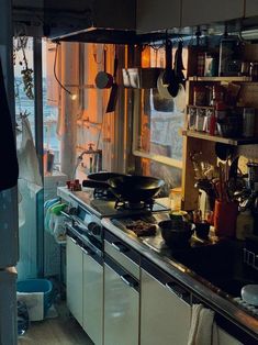 a kitchen filled with lots of clutter and cooking utensils