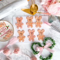 a table topped with lots of cookies covered in frosting next to flowers and candles