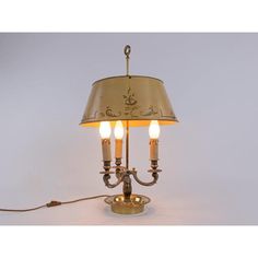 a lamp with three lights on it and a cord attached to the light fixture that is plugged in