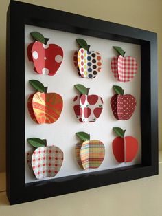 an apple shadow box with paper cut out of it's sides and apples on the inside