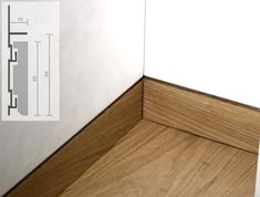 the corner of a room with wood flooring and white walls, showing an angle view