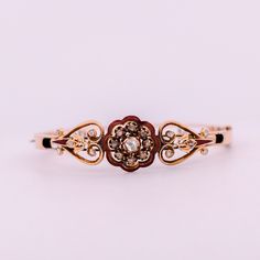 Embrace the enchanting allure of the Victorian era with this exquisite antique bracelet. Crafted in 14K rose gold, this stunning piece features a delicate outline of a red enamel flower, adorned with shimmering rose-cut diamonds, bezel, and prong set. The heart-shaped sides add a touch of romantic elegance to the design, transporting you to a time of opulence and refined beauty. The 14K rose gold setting serves as the perfect backdrop for the diamonds and enamel, enhancing their beauty and addin Luxury Gold Bangle With Rose Cut Diamonds, Vintage Rose Cut Diamond Bracelet, Vintage Round Bracelet With Single Cut Diamonds, Classic Rose Cut Diamond Bracelets For Formal Occasions, Vintage Diamond Bracelet With Single Cut Diamonds For Wedding, Luxury Yellow Gold Bracelets With Rose Cut Diamonds, Luxury Gold Bracelets With Rose Cut Diamonds, Victorian Diamond Bracelets For Gifts, Victorian Diamond Bracelets As Gift