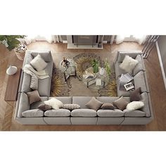 an overhead view of a living room with grey couches and white pillows on the floor