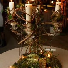 a table with candles and moss on it