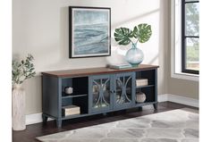 a living room with a rug and a painting on the wall above it, along with a blue cabinet