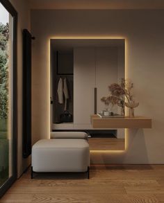 a white bench sitting in front of a mirror on top of a wooden floor next to a window