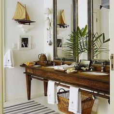 a bathroom with a sink, mirror and potted plant