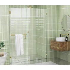 a green tiled bathroom with a glass shower door