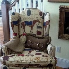 an upholstered chair with horse print on it in front of a stair case