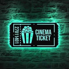 a neon sign that says cinema ticket on it's side against a brick wall