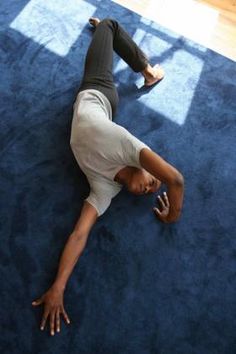 a man is laying on the floor with his hands behind his head and feet up