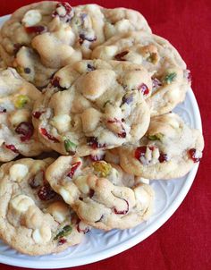 white chocolate cranberry cookies stacked on top of each other in front of a red tablecloth