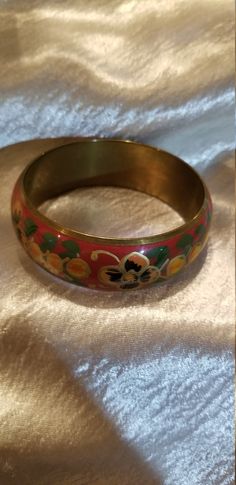 Thick Red floral enamel bracelet Enamel over brass with a red background and yellow and orange flowers with hints of gold and green leaves. Some tarnish on inside but otherwise in very good condition 2 1/2 In. inner diam best for a smaller wrist Just a teensy bit under one inch thick Yellow And Orange Flowers, Enamel Bangle, Gold And Green, Enamel Bracelet, Gorgeous Bracelet, One Inch, Design Silver, Photo Bracelet, Cuff Bangles