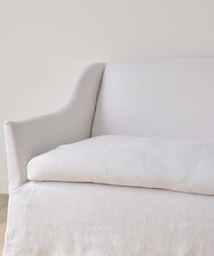 a white couch sitting on top of a hard wood floor