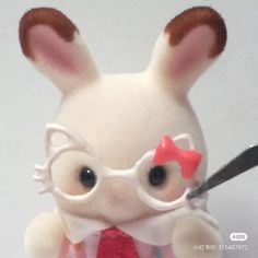 a white stuffed animal with glasses and a red tie holding a pair of scissors in it's hand