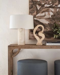 two blue stools sitting under a painting on the wall