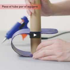 a person is making a tube out of cardboard and glues it with their hands