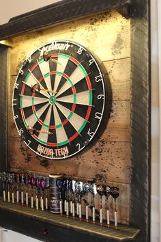 a dart board mounted to the side of a wall with darts in front of it