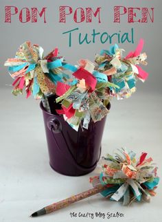 a purple vase filled with lots of colorful paper flowers next to a small flower pinwheel