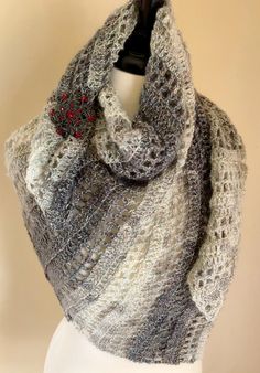 a gray and white knitted shawl on a mannequin headdress