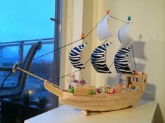 a toy boat that is made out of wood and painted with black and white stripes