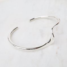 Sterling Silver Cuff with Single Wave The cuff bracelet is an eternal classic and a must-have for every jewelry collection. Stack them, combine plain with texture, mix with stone bracelets, the possibilities are endless. Bright Sterling Silver Approx. 1.9" x 2.5" inner dimensions Handmade in Thailand - Handpicked in Person by our Buyers Modern Adjustable Bangle With Polished Finish, Everyday Metal Cuff Bracelet With Polished Finish, Everyday Polished Metal Cuff Bracelet, Modern Twist Polished Bangle Cuff Bracelet, Modern Adjustable Open Cuff Bracelet, Modern Metal Stackable Cuff Bracelet, Modern Adjustable Open Band Bracelets, Modern Adjustable Open Band Bracelet, Adjustable Modern Open Band Bracelets