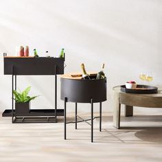 two round tables with drinks on them in front of a white wall and wooden floor