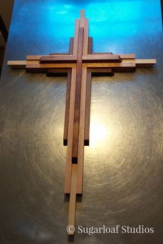 a wooden cross sitting on top of a metal surface