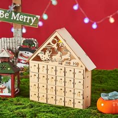 a christmas scene with a wooden house and snowman figurines on the ground