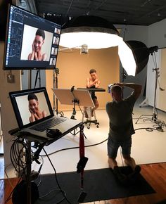 two men in front of a laptop on a camera set up for a photo shoot