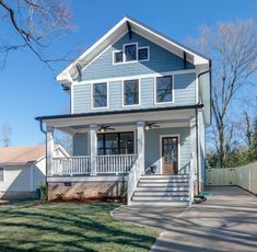 a blue two story house with white trim on the front porch and stairs leading up to the second floor