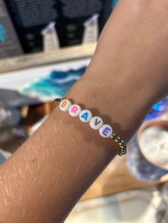 a person wearing a bracelet with letters on it