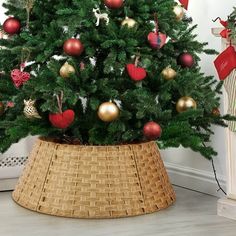 a small christmas tree in a basket on the floor