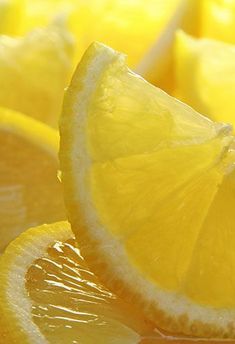 sliced lemons sitting on top of a table next to other pieces of fruit and vegetables