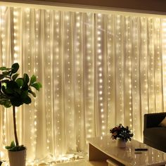 a living room with lights on the walls and a couch next to a table in front of a window