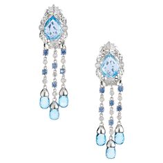 Crafted to perfection, these dangle earrings feature stunning blue topaz gemstones beautifully accentuated by dazzling diamonds and sapphires, in 14k white gold settings. At the center of each of these earrings are a pair of 2.50ct pear shaped topaz. Each earring has three dangle strands that consist of 6 bezel set round diamonds and 6 round cut sapphires. At the end of each dangle is a blue briolette topaz. vibrant blue hue of the topaz gemstones paired with the brilliance of diamonds creates a captivating contrast. 2 pear shape blue topaz, approx. 5.00cts 6 blue topaz briolette's, approx. 3.00cts 22 round diamonds, I-J I approx. .22cts 12 round sapphires, approx. .70cts 14k white gold Stamped: 585 15.7 grams Top to bottom: 52.8mm or 2 Inches Width: 13.8mm or .54 Inches Depth or thickness Luxury Brilliant Cut Blue Earrings, Antique Sapphire Rings, Luxury Brilliant Cut Blue Topaz Earrings, Light Blue Gemstone Earrings - Fine Jewelry, Classic Blue Diamond-cut Earrings, Elegant Blue Diamond-cut Earrings, Vintage Antique Engagement Rings, Antique Wedding Bands, Diamond Sapphire Engagement Ring