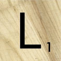 a close up of a piece of wood with the letter l in black on it