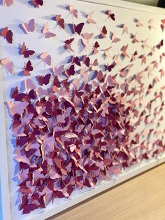 a wall with pink and purple butterflies on it's side, in front of a wooden table