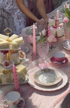 a table topped with plates and cups filled with cake