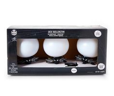 three white balls in a box with black bows on them, sitting side by side