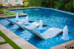 an outdoor swimming pool with water features