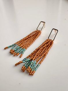 These earrings are the perfect length and will go with any outfit! The gold open rectangle posts are adorned with sienna and turquoise relics seed beads.  They are so lightweight you won't even notice you are wearing them :)  Posts are nickel and lead free Bohemian Rectangular Beaded Earrings With Dangling Beads, Bohemian Rectangular Earrings With Colorful Beads, Bohemian Rectangular Earrings With Dangling Beads, Bohemian Rectangular Dangling Bead Earrings, Bohemian Gold Rectangular Beaded Earrings, Bohemian Beaded Rectangular Earrings, Turquoise Seed Bead Earrings, Turquoise Metal Dangle Beaded Earrings, Turquoise Metal Beaded Bohemian Earrings