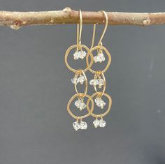 "14k Solid Gold Herkimer Diamond Dangle Earrings.  These playful solid gold dangle earrings have a waterfall of Herkimer Diamonds tumbling through three irregular shaped 14k gold hoops. Herkimer diamonds are double-terminated quartz crystals - they have a lovely sparkle that plays off the swiveling gold hoops and glint as they catch and reflect the light.  They are 14k solid gold and measure 2.25\" long by 0.5\" wide. They are handmade to order.  All designs come in a box ready for gifting." Herkimer Diamond Earrings, Dangle Earrings Gold, Gold Dangle Earrings, Diamond Jewel, Diamond Dangle Earrings, Wide Band Rings, Raw Diamond, Quartz Crystals, Herkimer Diamond