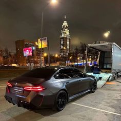 a car is parked on the side of the road in front of some buildings at night