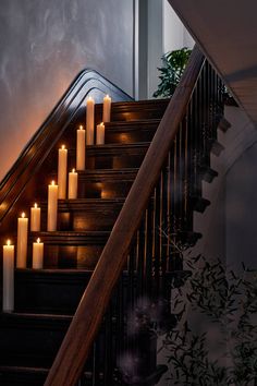 candles are lit on the stairs in front of an open door