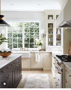 an image of a kitchen setting with white cabinets and marble counter tops in the middle