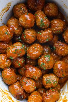 the meatballs are covered in sauce and garnished with parsley