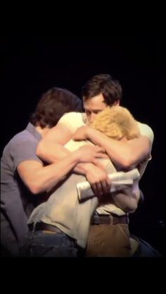 two men hugging each other on stage