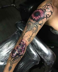 a woman's arm with flowers on it and an instagramt for her