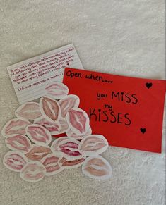 a red note and some pink lipstick on a white surface with hearts in the middle